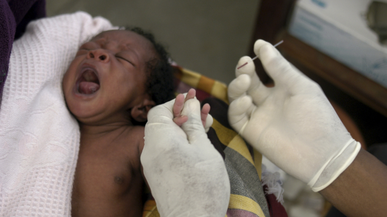 A nurse takes blood sample from a baby to test for malaria in Manhia, Mozambique. AMO/ L. W.