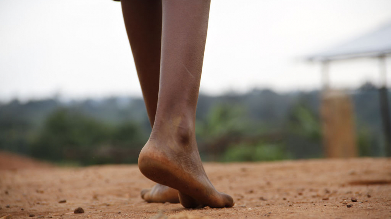 On 29 May, Centia, 12, walks barefoot across dusty ground in Kirundo Province, Burundi. Photo credit: UNICEF/UNI186074/Nijimbere