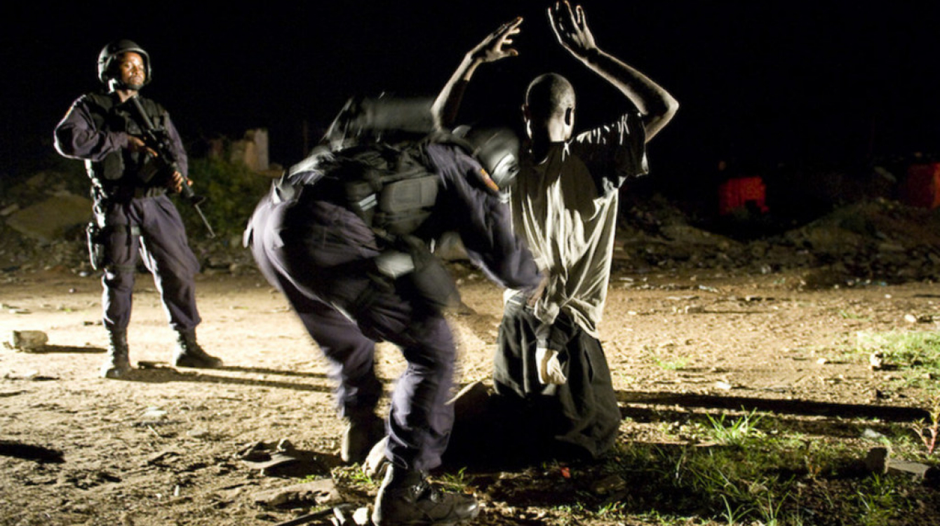 Crédits Photo:  MINUL/Christopher Herwig.  Au milieu de bâtiments abandonnés du centre-ville de Monrovia, une personne suspectée de transporter de la drogue et des armes est fouillé.