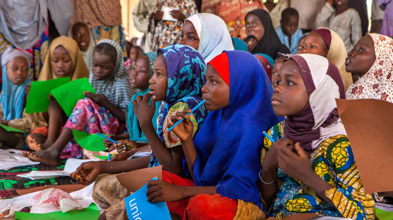 Girls use their new school supplies during a class in an informal learning centre in a UNICEF-supported safe space for children in the Dalori camp for internally displaced people, in the north-eastern city of Maiduguri in Borno State. Photo: UNICEF/UNI193