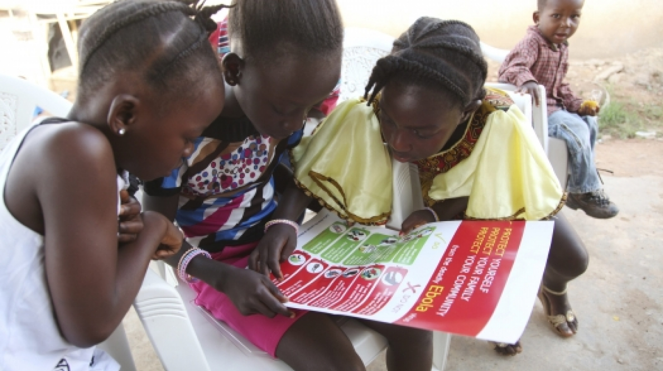 Girls in Voinjama, Liberia, look at a poster that displays information on Ebola.   Photo: UNICEF/Liberia/Jallanzo