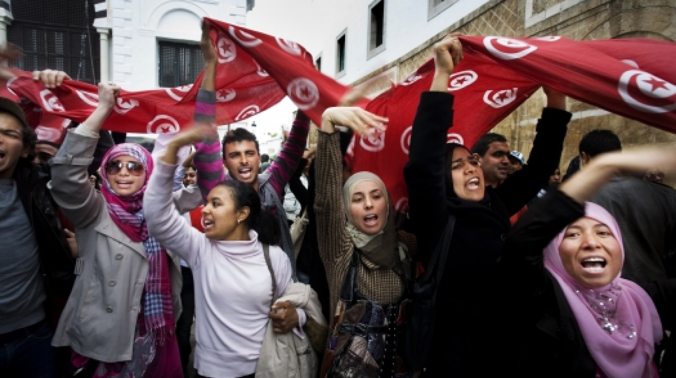 Agitating for change: Women wave flags during a demonstration in Kasbah Square, Tunis.     Photo: Panos / Alfredo D’Amato