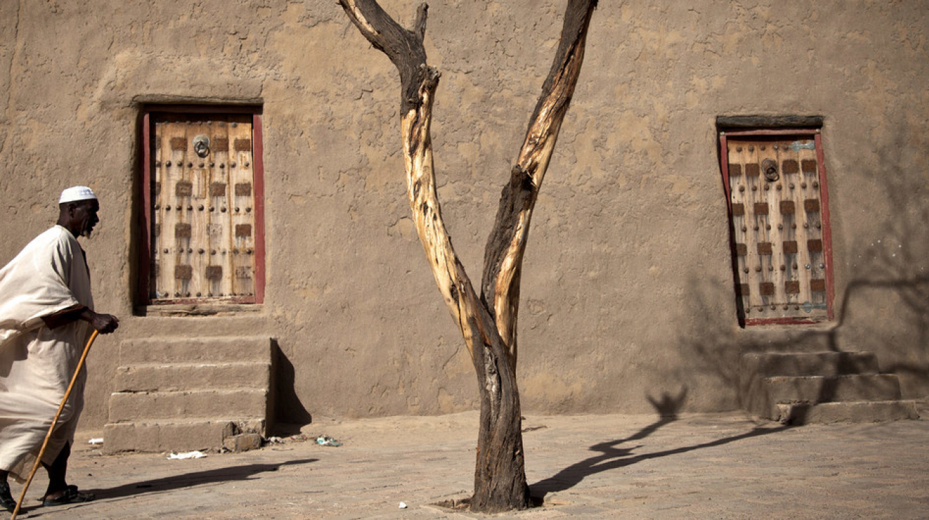 A resident walks past Djingareyber Mosque in Timbuktu, Mali, once a legendary city with a large collection of treasured manuscripts, now an endangered UNESCO World Heritage Site.