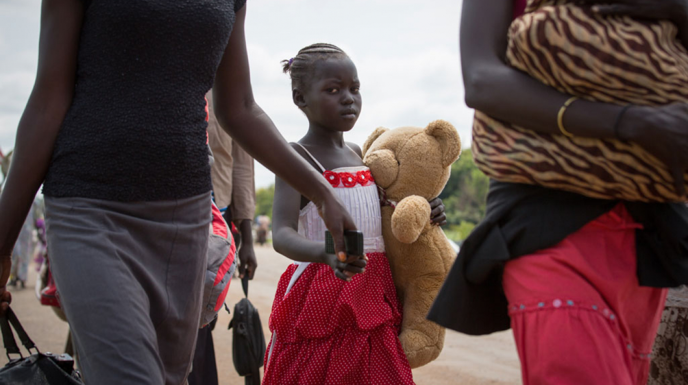 A young refugee and her family cross the border between South Sudan and Uganda. Photo: UNHCR/Will Swanson