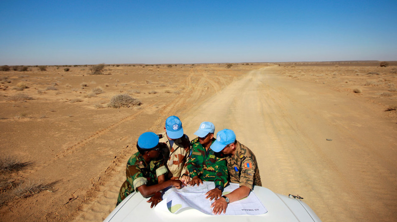 Peacekeepers with the UN Mission for the Referendum in Western Sahara (MINURSO) consult a map as they drive through vast desert areas in Smara, Western Sahara. Photo Credits:UN Photo/Martine Perret