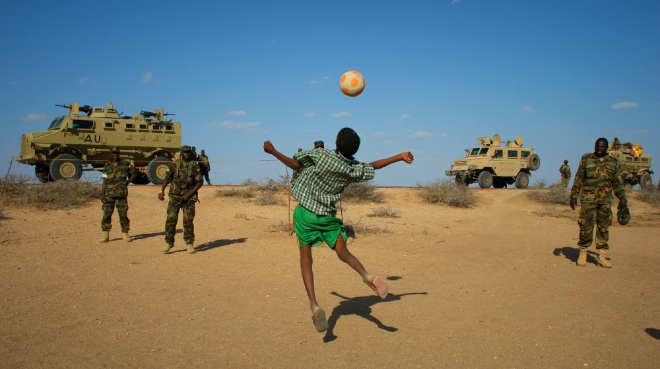 Des soldats ougandais de l’AMISOM jouent au football avec des enfants somaliens après avoir repris le contrôle d’une ville à Al-Shabab- Photo: IRIN