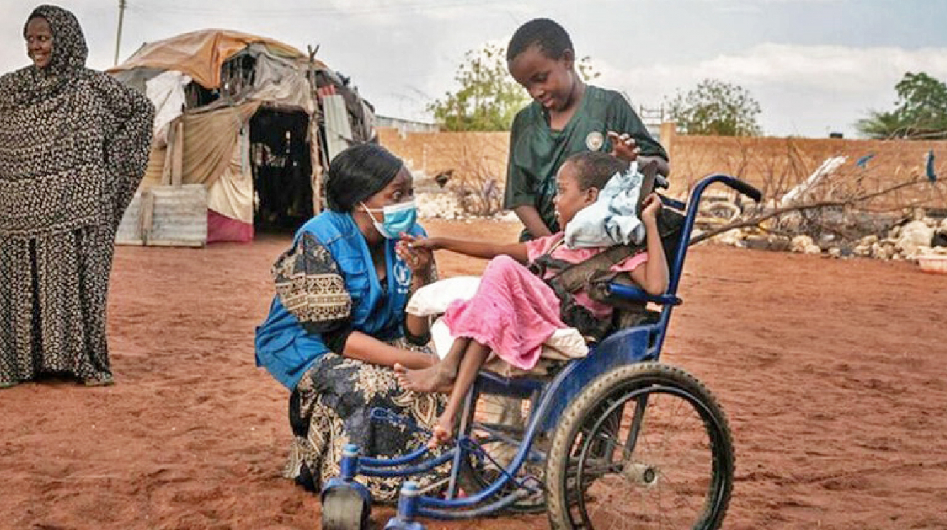 Eight year old girl in wheelchair with head of Wajir field office and her family.