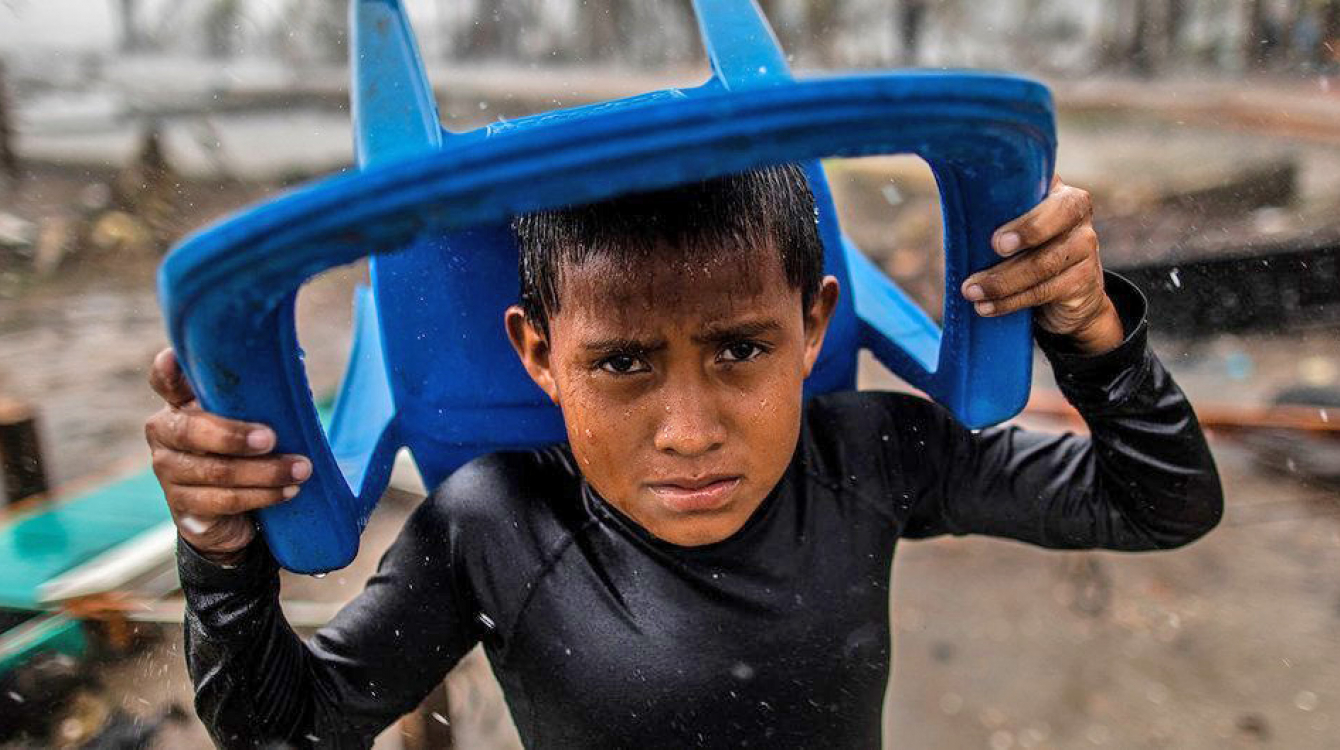 Jeune garçon en Amérique centrale essayant de se protéger de la tempête.