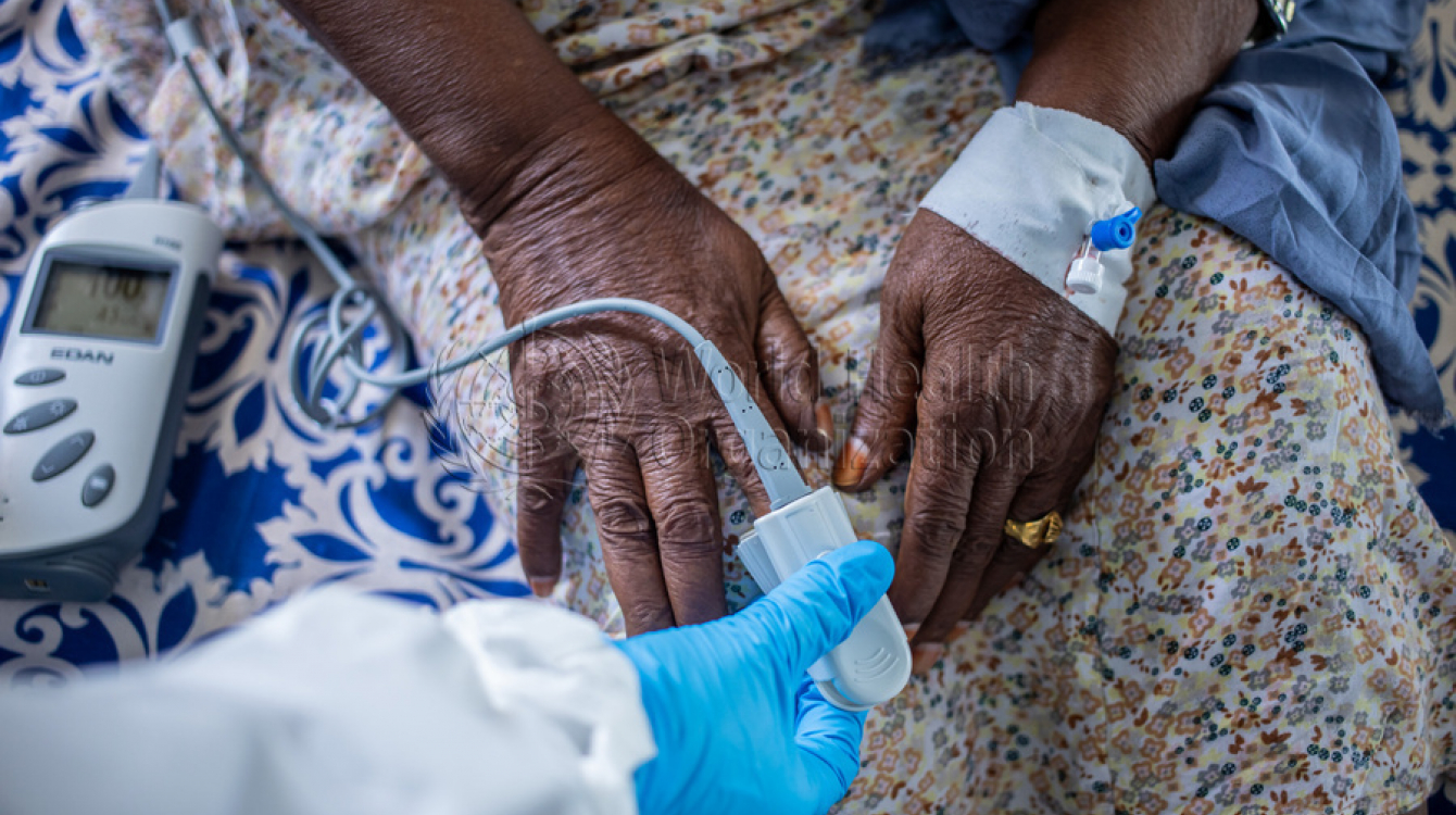 Un agent de santé utilise un oxymètre de pouls au doigt.