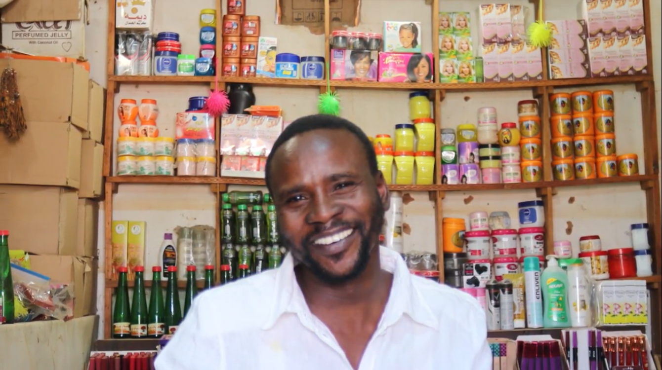 IOM helped Mohammad Ahmad to set up a shop in OMduram market, near Khartoum, Sudan. The initiative involves using mobile money to buy goods