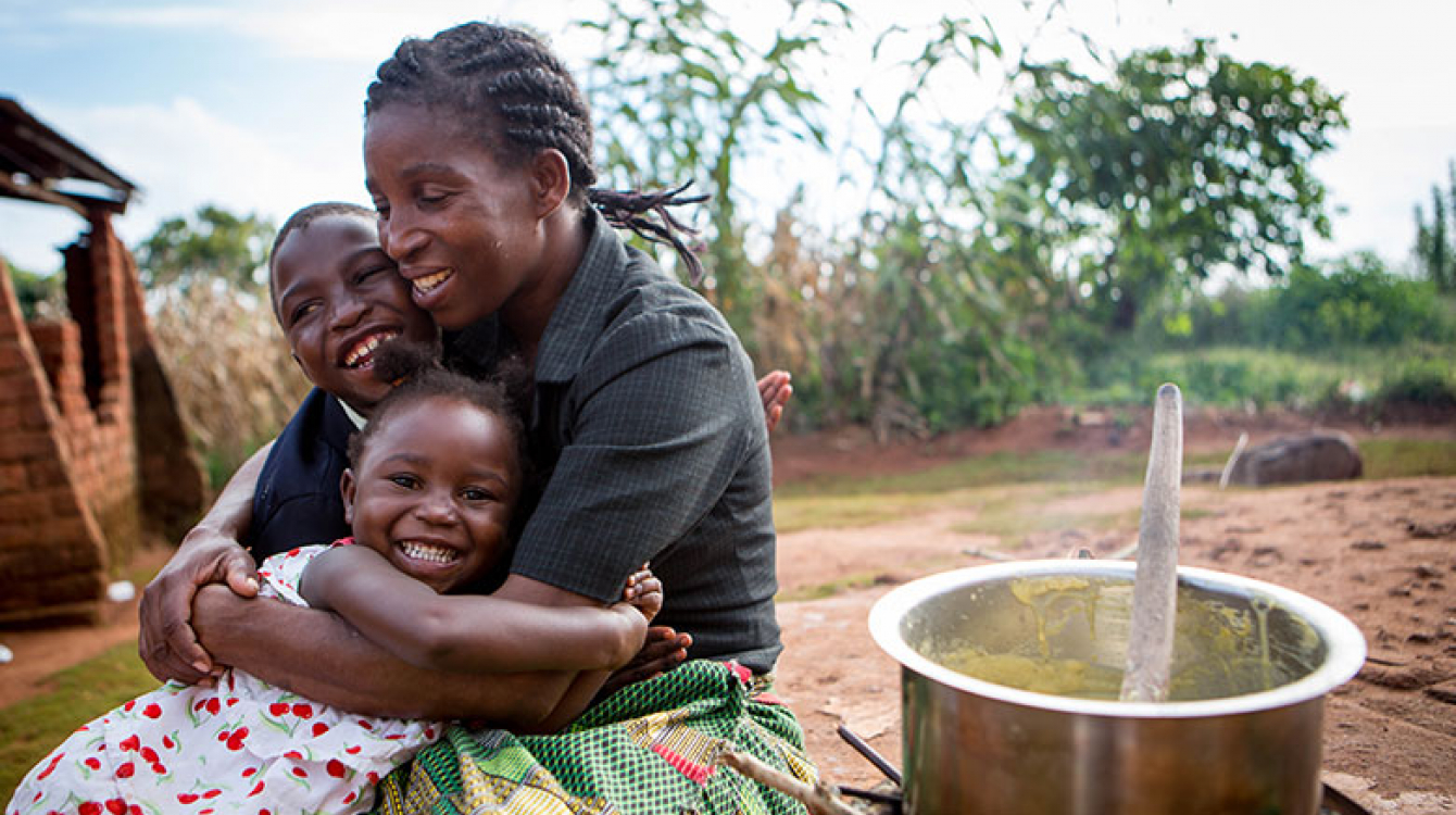Happy children as their mother prepares porridge.