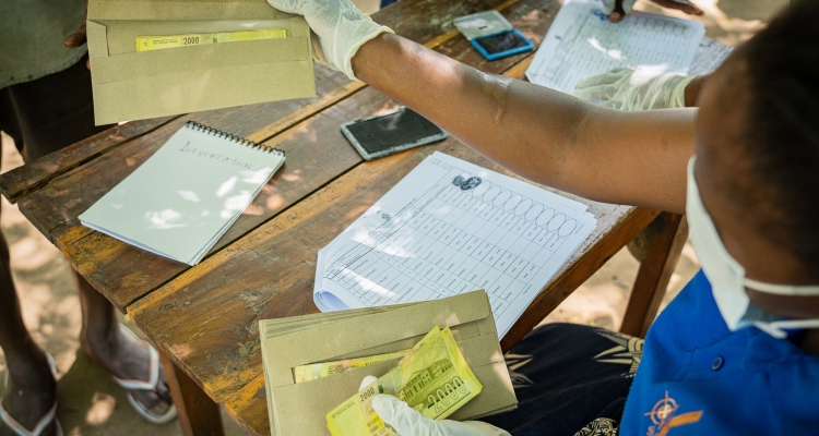 Worker wearing protective gear handling documents and money