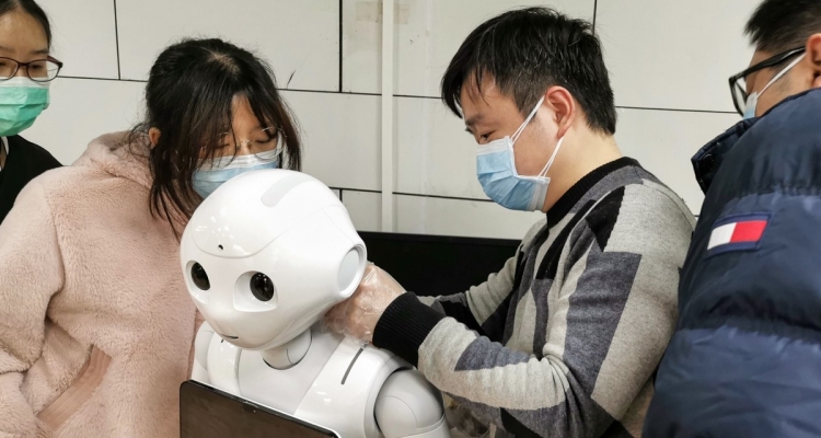 Individuals wearing protective gear working on robot