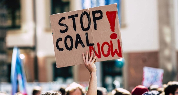 Un panneau indiquant "stop au charbon maintenant" est brandi lors d'une manifestation.