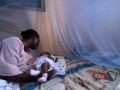 Infant surrounded by protective malaria bed net in Ghana. Photo: World Bank/Arne Hoel