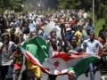 Demonstrators carry a Burundi flag during a protest in Bujumbura, Burundi. Photo: Reuters/G. Tomasevic 