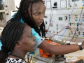 Two students practicing with wind, solar and other models on computer.