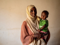 Hayat stands with her child who is being treated for malnutrition 