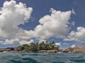 Island with water in foreground and blue sky above.