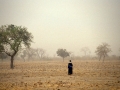 A woman walking through fields in Mali.