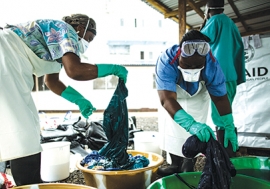 Health workers clean hospital scrubs and protective gear at the Island Clinic for Ebola treatment centre in Monrovia, Liberia, during the 2014 Ebola outbreak.   USAID/Morgana Wingard