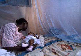 Infant surrounded by protective malaria bed net in Ghana. Photo: World Bank/Arne Hoel