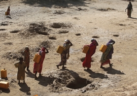 Women carry jerry cans of water from shallow wells dug from the sand along the Shabelle River bed, following a drought in Somalia. Photo: Reuters/Feisal Omar