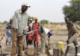 Salva Dut (left) pumps water from one of the boreholes he has helped drill in South Sudan. Photo: Water for South Sudan