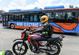 A motor bike rider in Nairobi, October 19, 2022, next to an electric bus 