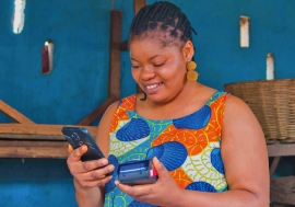 African woman entrepreneur with digital payment device.