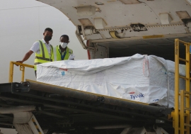 Staff unload the first shipment of COVID-19 vaccines distributed by COVAX at Kotoka International Ai