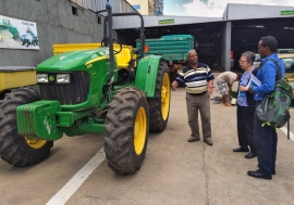 Factory worker in Ethiopia explaining tractor use to colleagues.