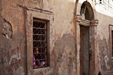 A girl looks out of her house window in Benghazi, Libya. Photo: UNSMIL