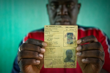 Un homme répondant au nom de Oumar, qui risquait de devenir apatride, brandit la carte d’identité de son père, datant de l’époque coloniale française. Photo : HCR/Hélène Caux