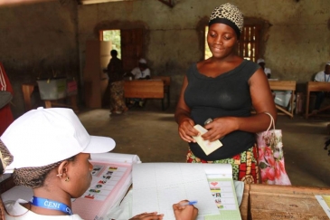 An electoral worker checks names against the voters' list at a polling station during elections in Burundi. Photo: MENUB