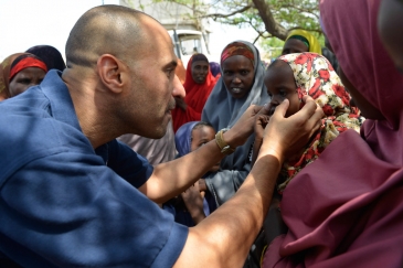 World Health Organization (WHO) official, Dr. Ahmed El Ganainy, checks the eyes of a little girl during a joint humanitarian assessment mission to Marka, Somalia, on 9 July 2014. UN Photo/David Mutua