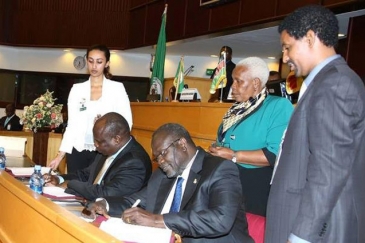 Former South Sudan Vice President Riek Machar (seated right) and Pagan Amum Okiech, representing the Former Detainees, sign the compromise peace agreement put forth by the Intergovernmental Authority on Development Partners Forum (IGAD) mediation in Addis