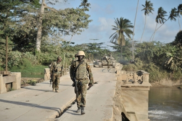 Ugandan soldiers serving with the African Union Mission in Somalia (AMISOM), walk across a bridge near the town of Janaale, Somalia.