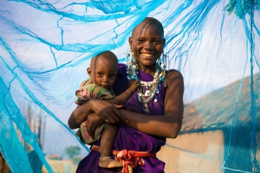 Une mère souriante avec son jeune garçon sous un filet insecticide, à Arusha, en Tanzanie. 