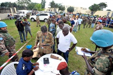 Des officiers de l’ONUCI mènent une opération de désarmement, de démobilisation et de réinsertion avec des ex-combattants dans le quartier d’Abobo à Abidjan en février 2012. Photo ONU/Hien Macline