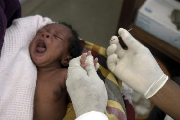 A nurse takes blood sample from a baby to test for malaria in Manhia, Mozambique. AMO/ L. W.