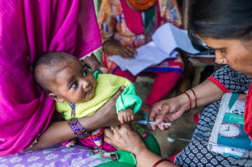 Mkunga awapa chanjo dhidi ya polio Mama na mtoto wake mchanga.