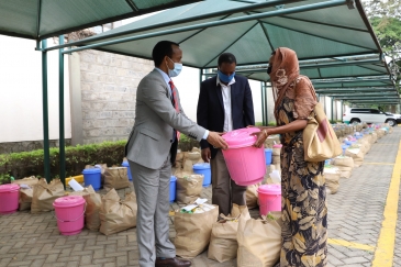 Meles Alem, Ethiopian Ambassador to Kenya handing over food donation to one of the beneficiaries.