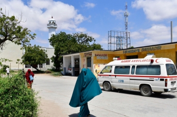 Mwanamke akipita pembeni ya gari la wagonjwa ndani ya hospitali ya Benadir mjini Mogadishu, Somalia.