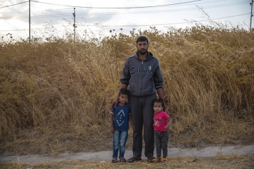 Baba mzazi kutoka Syria anasimama na watoto wake katika kambi ya Bardarash mjini Duhok, Iraq, siku moja baada ya kuwasili.