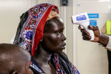 An internally displaced woman voluntarily returning to her home in Bentiu, South Sudan, is being checked for fever.