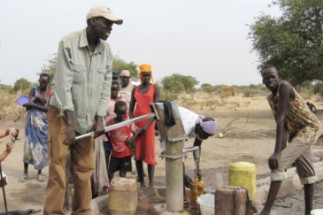 Salva Dut (left) pumps water from one of the boreholes he has helped drill in South Sudan. Photo: Water for South Sudan