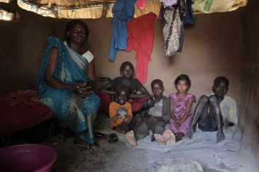 Mary Amaik and her family sit in their small house in Pibor, South Sudan.