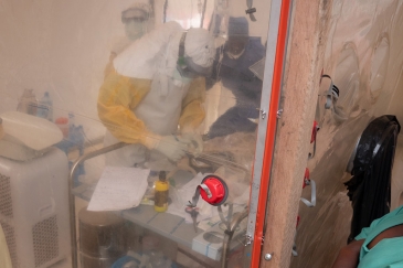 An Ebola health care worker examines a one week old infant in an isolation tent at an Ebola treatment center in Beni, North Kivu, Democratic Republic of the Congo. 3 December 2018.