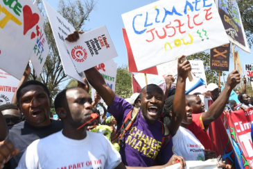 Environmental activists carrying placards protest calling for action on climate change.